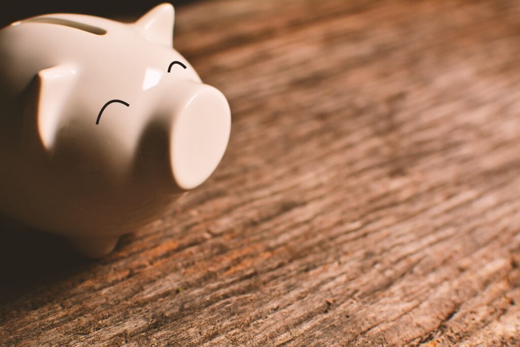 Pink piggy bank sitting on desk representing money saved on labor through adopting an AI platform